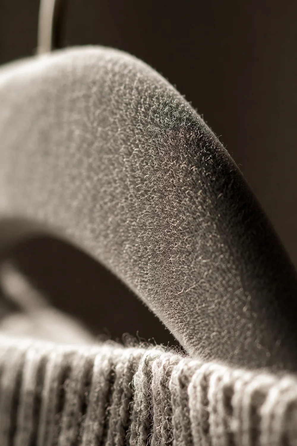Felt hanger liner gripping a knit sweater to prevent slipping