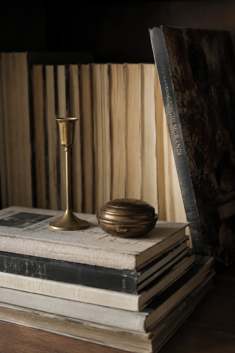 Close-up of stacked books styled as a shelf riser with spines turned inward