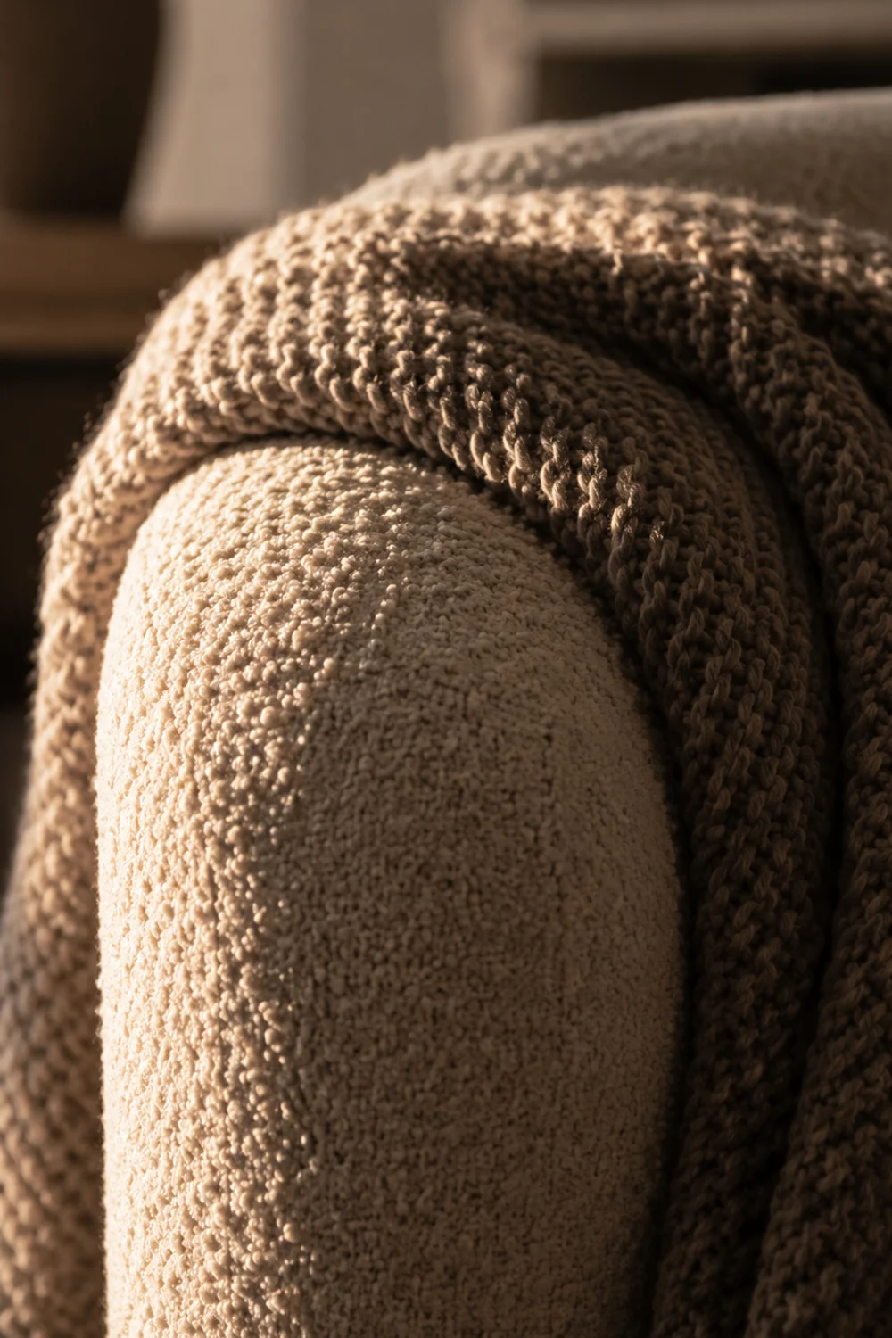 Close-up of bouclé chair texture with chunky knit throw blanket