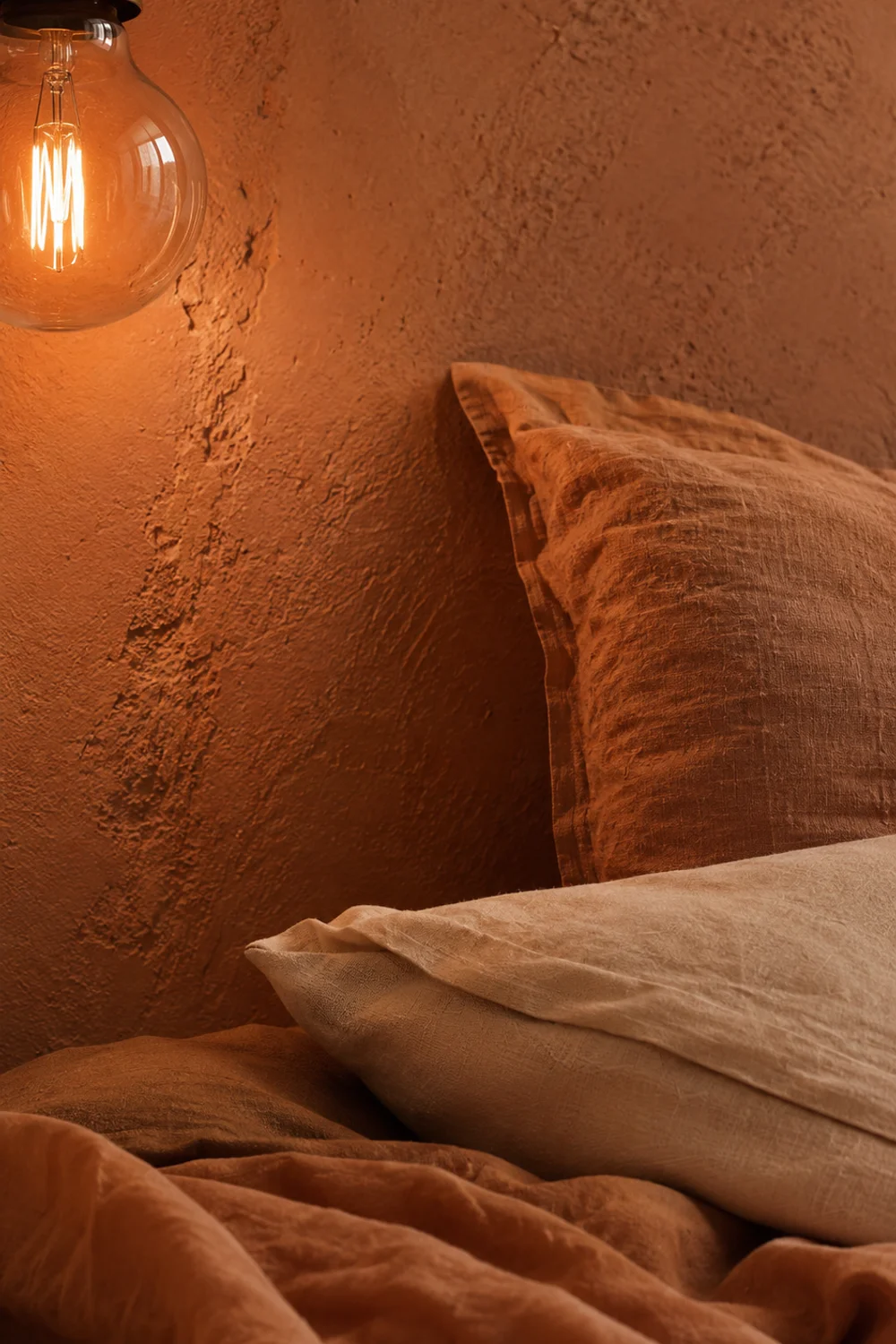 High-CRI warm light revealing true clay wall color and linen bedding texture