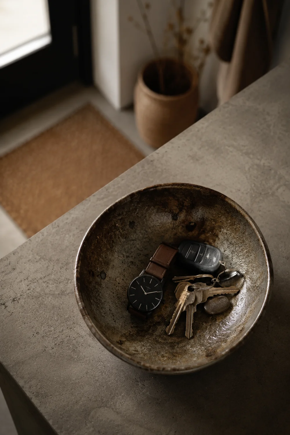 Deep ceramic catchall bowl holding keys and small items on kitchen counter